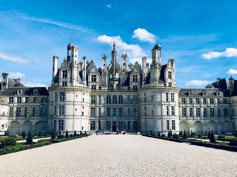 The long white facade of Chambord under a summer sky