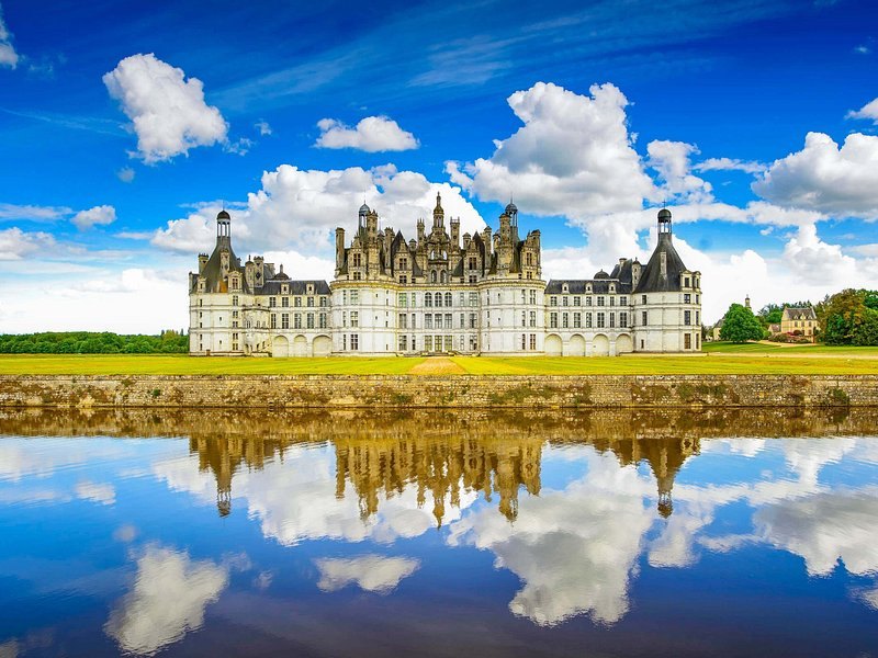 The Château de Chambord reflected full length in the still water of its canal