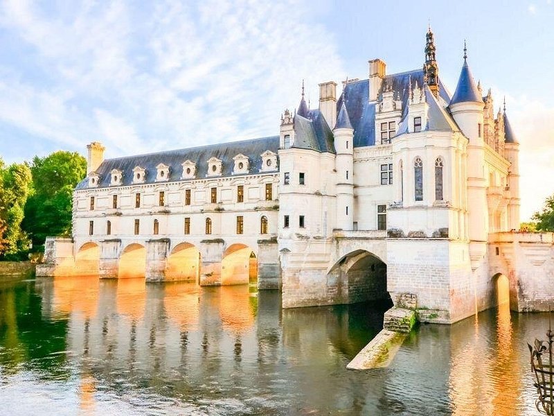 The arches of Chenonceau's gallery reflected in the Cher in soft evening light
